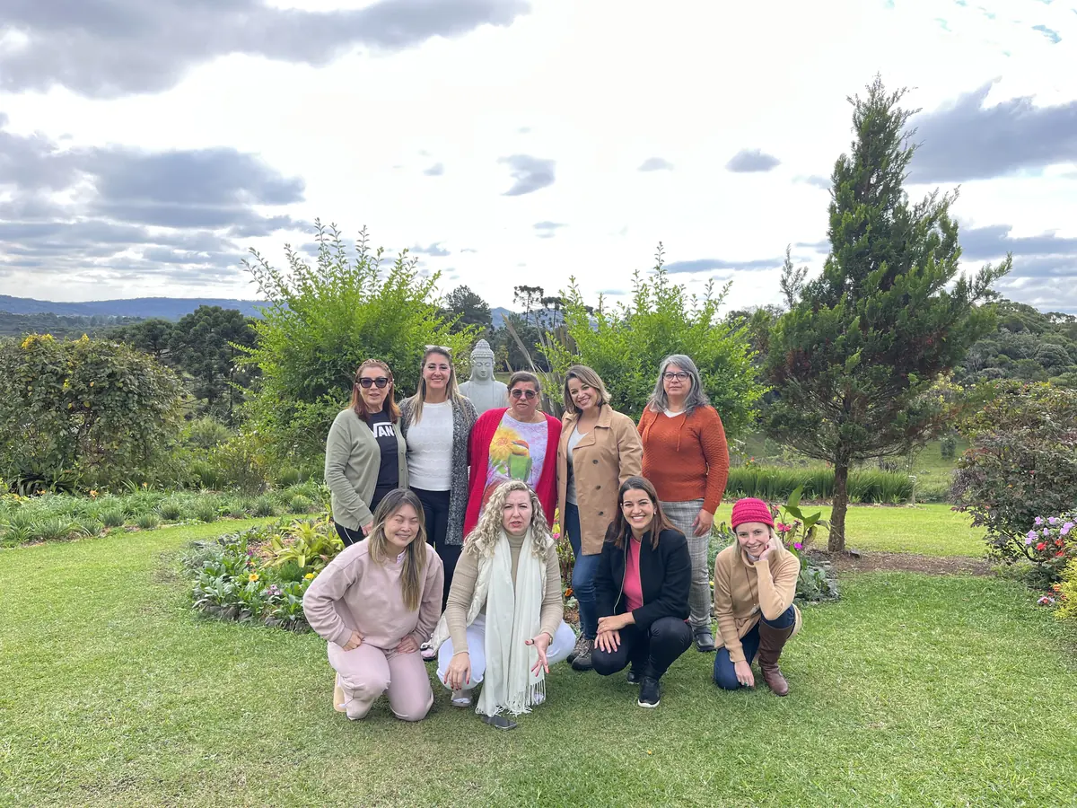 Grupo de mulheres reunido no jardim, com o vale ao fundo