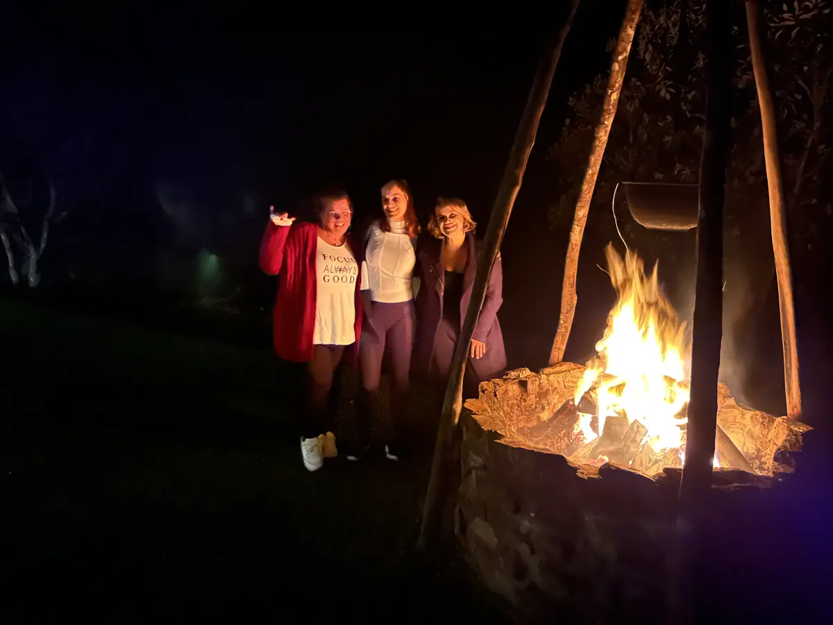 Mulheres juntas ao lado da fogueira, à noite